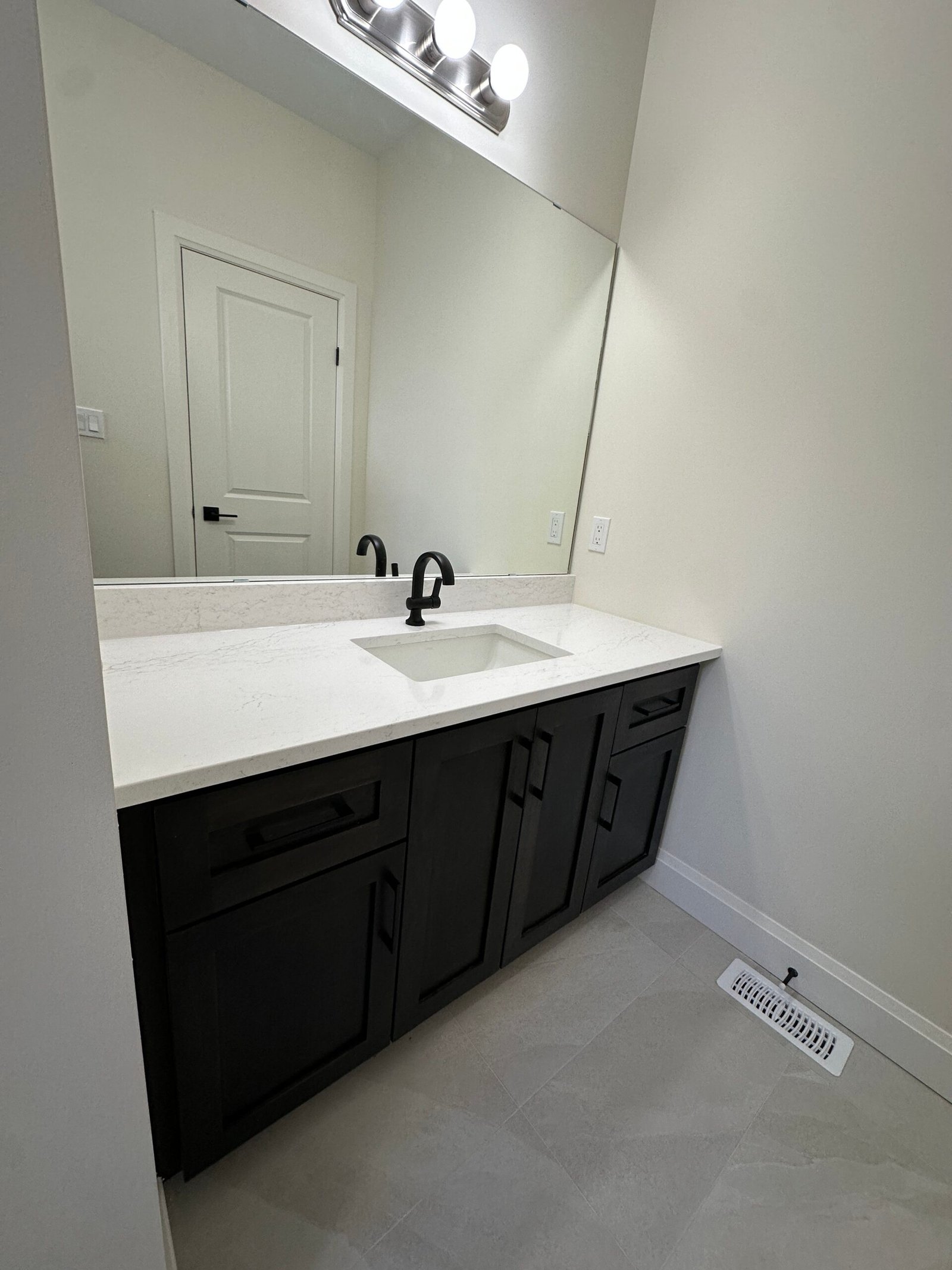 Upstairs bathroom with quartz countertop, undermount sink and dark stained vanity cabinetry