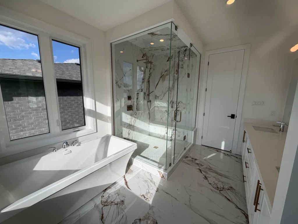 Primary ensuite with a freestanding tub beside a frameless glass shower