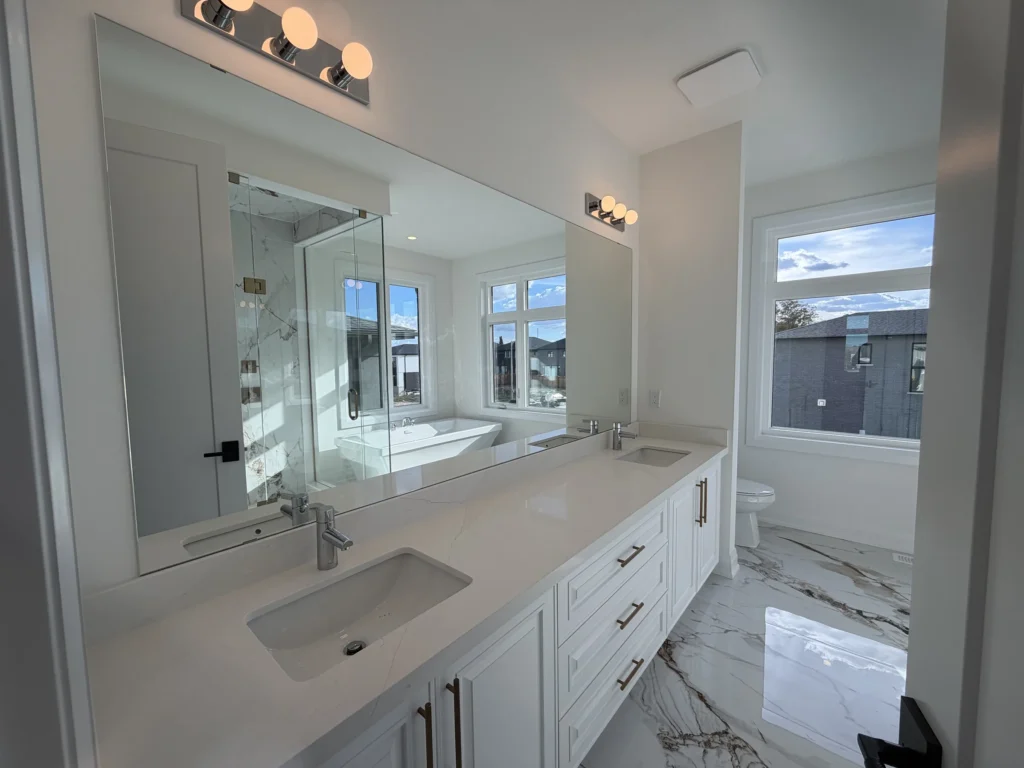 Long ensuite vanity with quartz countertop and a wall-width mirror