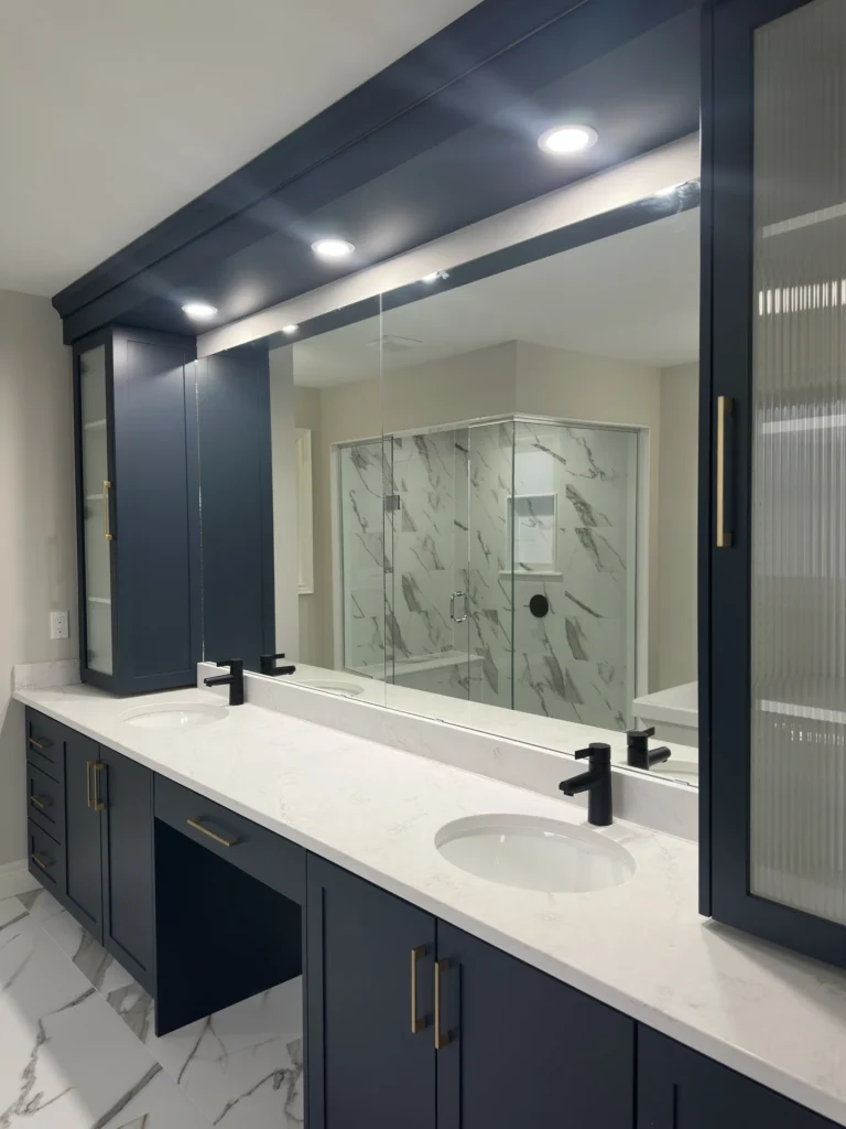 Navy double vanity with upper valance cabinets and pot lights