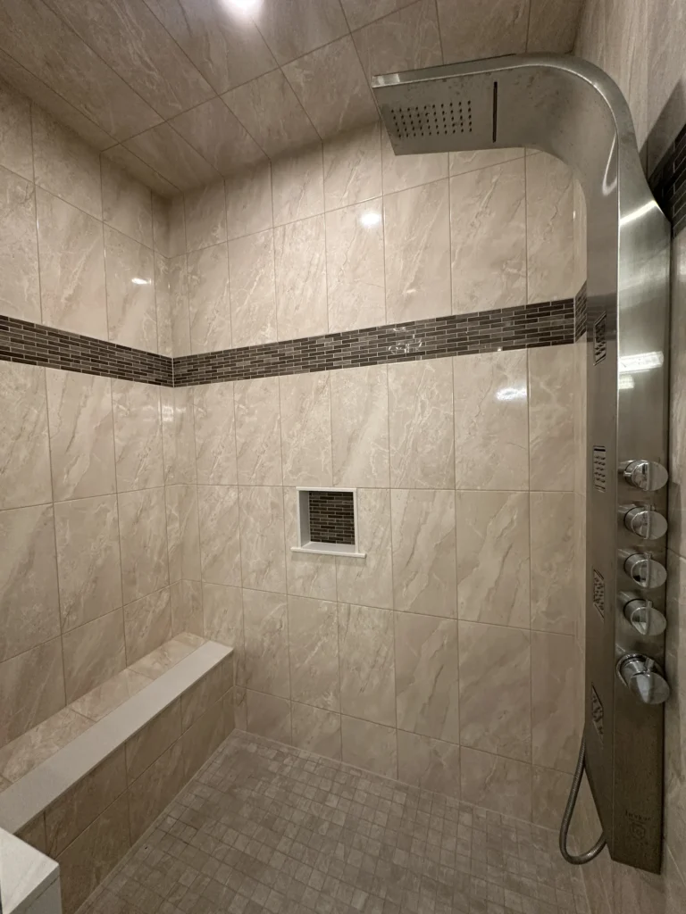 Tiled shower with a bench, niche and decorative accent band