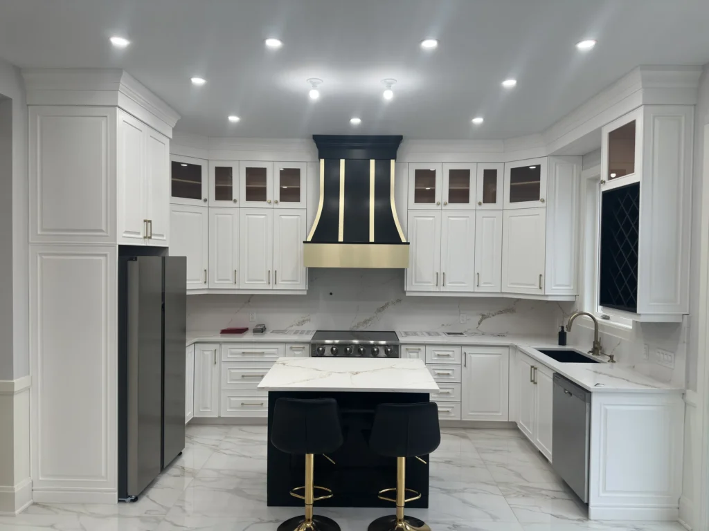 White custom kitchen with a black and gold range hood, navy island and gold bar stools in a Scarlett Homes new build in Hamilton