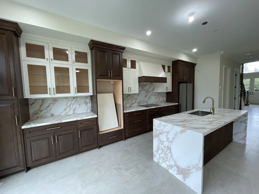 Kitchen with a marble-look waterfall island, walnut cabinetry and a full-height backsplash