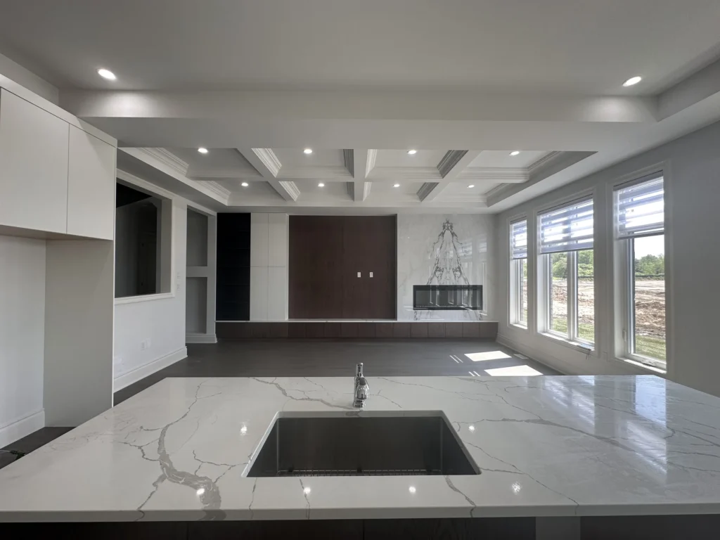 Quartz kitchen island opening onto a family room with a coffered ceiling