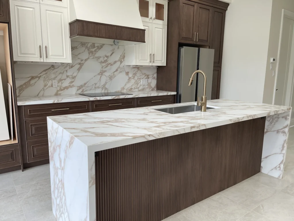 White custom kitchen with a black and gold range hood, navy island and gold bar stools in a Scarlett Homes new build in Hamilton