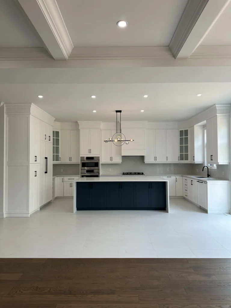 Full view of a white kitchen with a navy island and porcelain tile floors