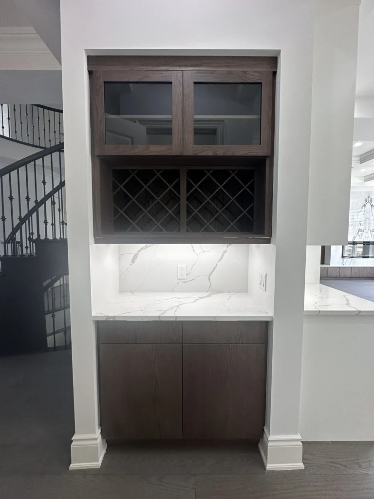 Servery with dark cabinets, wine rack and quartz counter