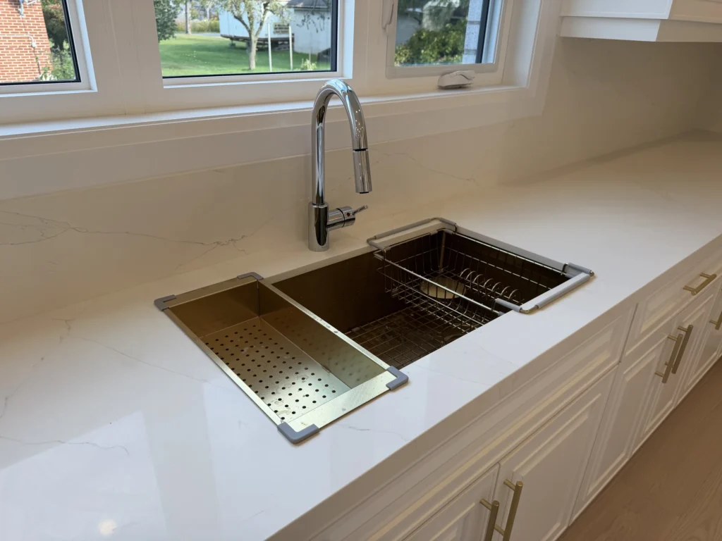 Stainless workstation sink set in a white quartz countertop