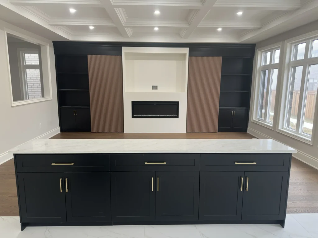 Built-in wall unit with walnut panels and linear fireplace, seen from the kitchen island