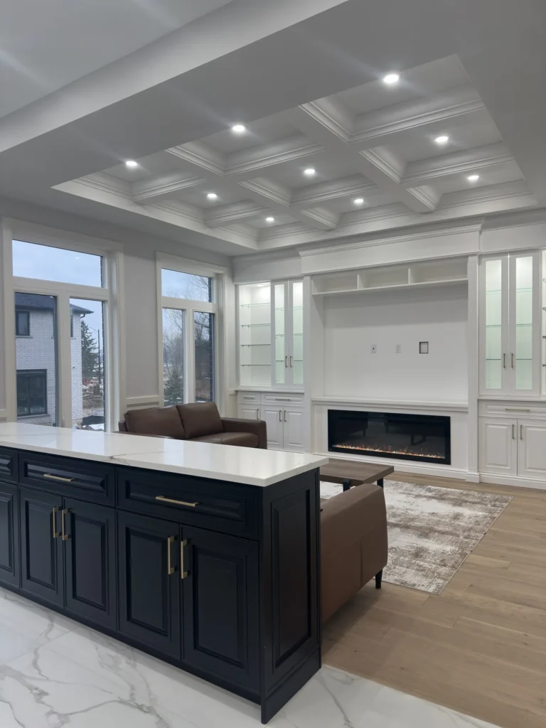 Family room viewed from the kitchen island, with coffered ceiling and fireplace