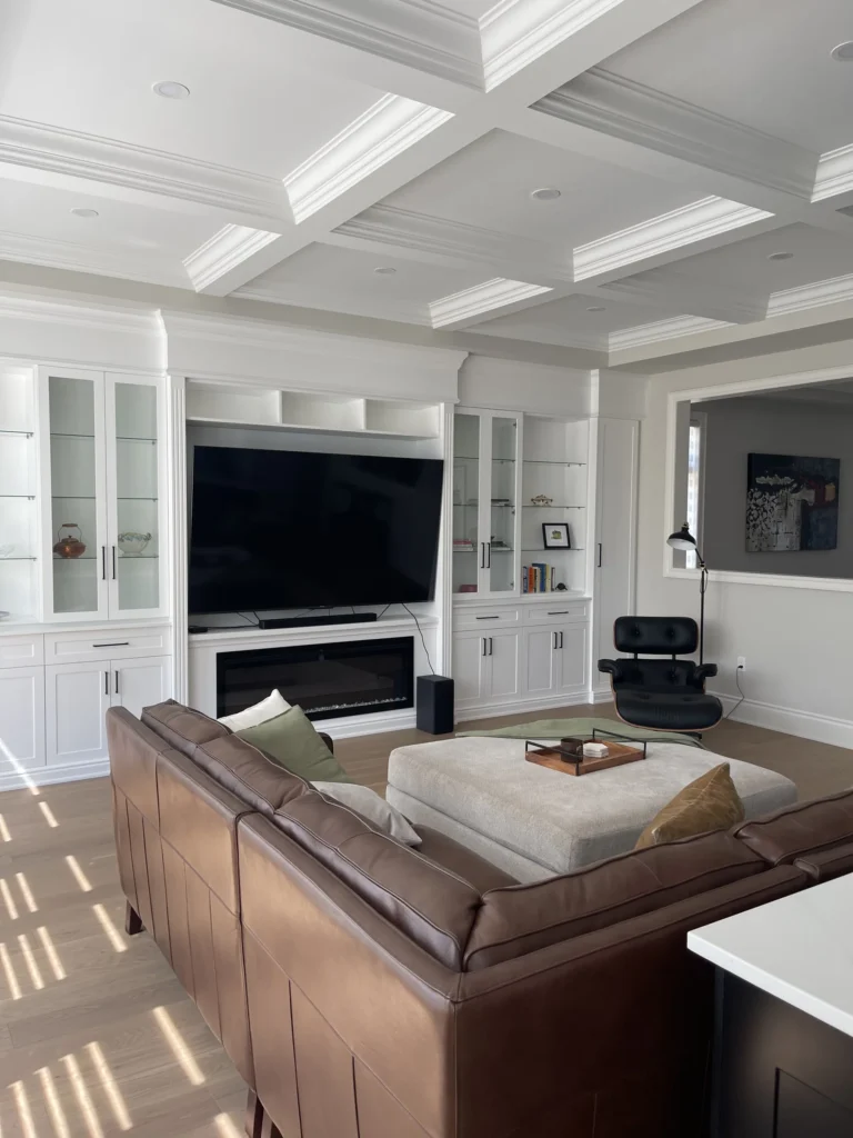 Family room with white built-in shelving, mounted TV and electric fireplace