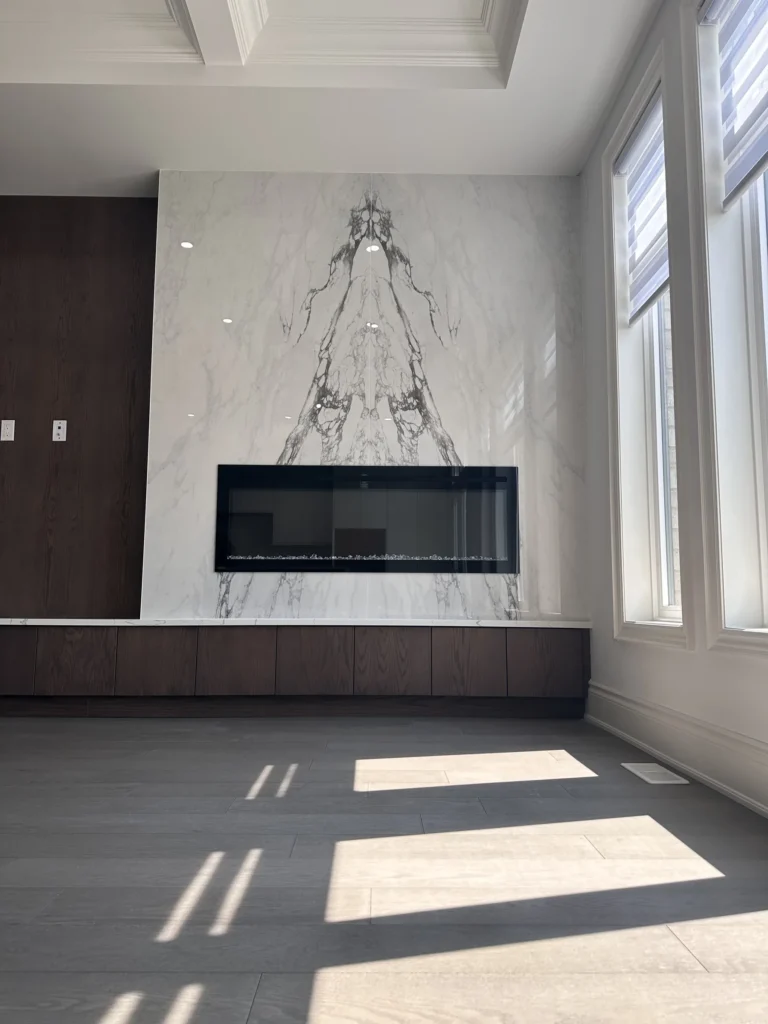 Family room feature wall in porcelain slab with linear fireplace and walnut panels