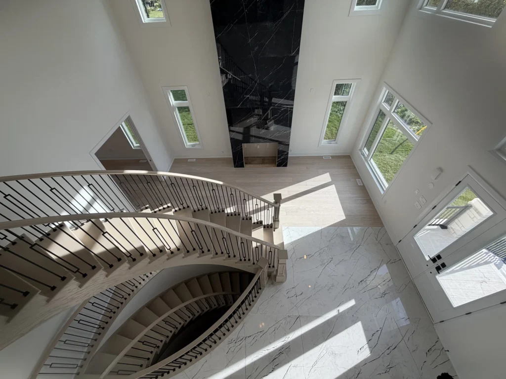 Curved oak staircase with iron spindles seen from the upper landing