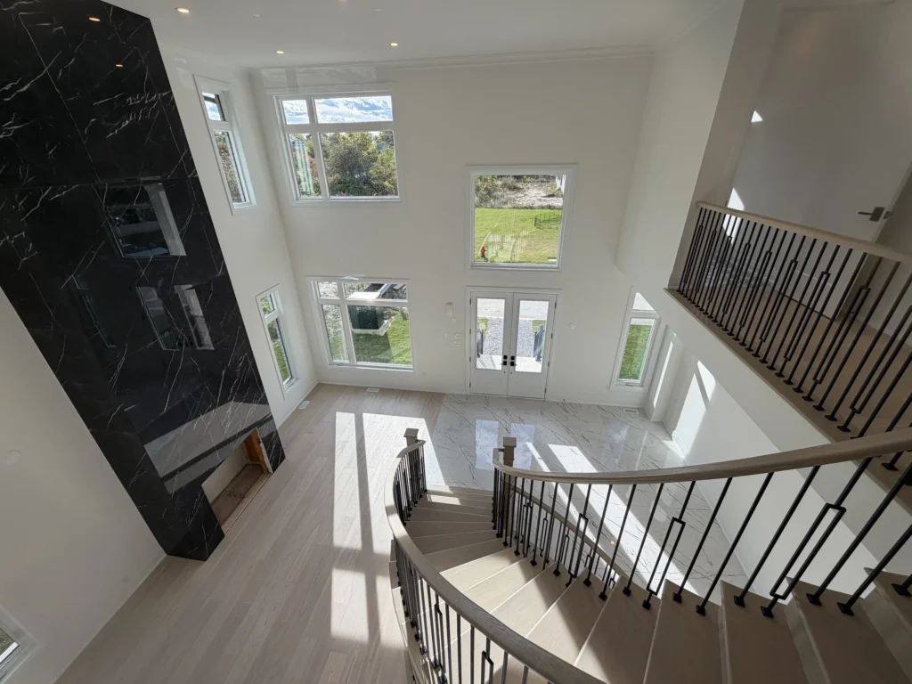 Open-to-above foyer with tall windows, seen from the upstairs landing