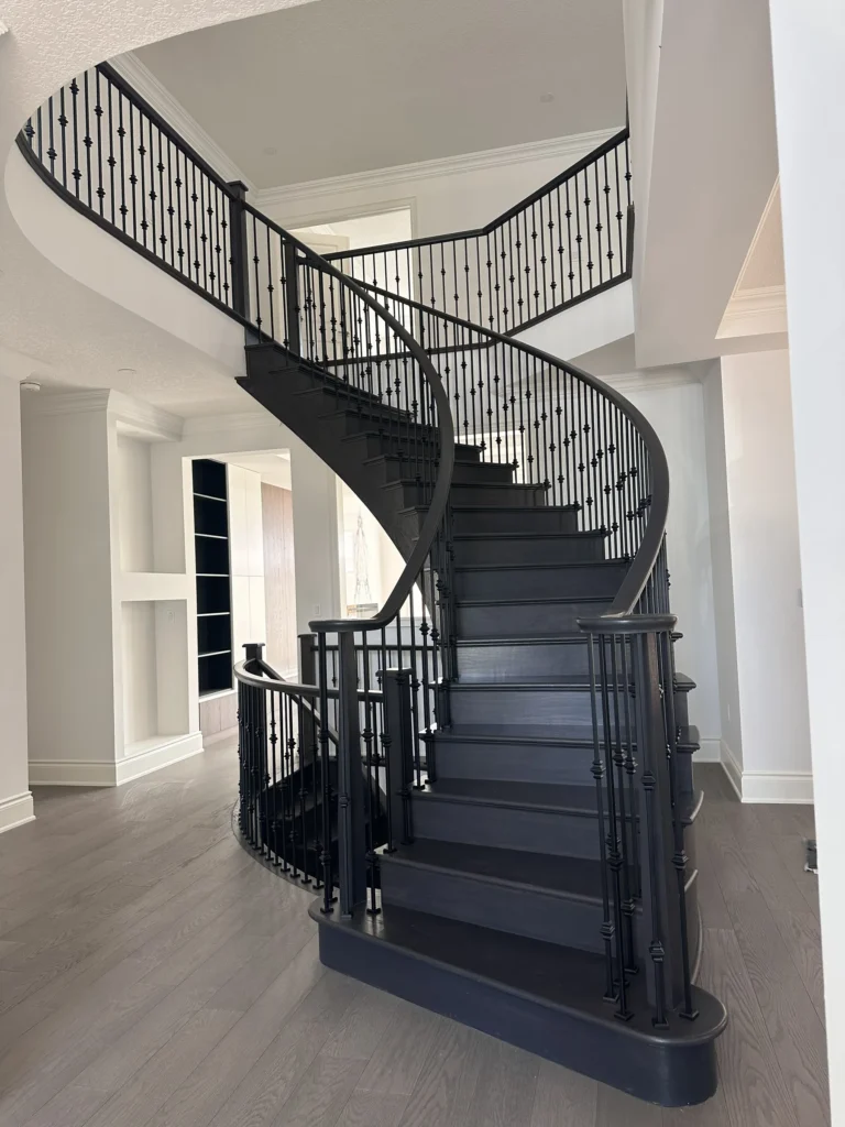 Curved staircase with black treads and black iron railing