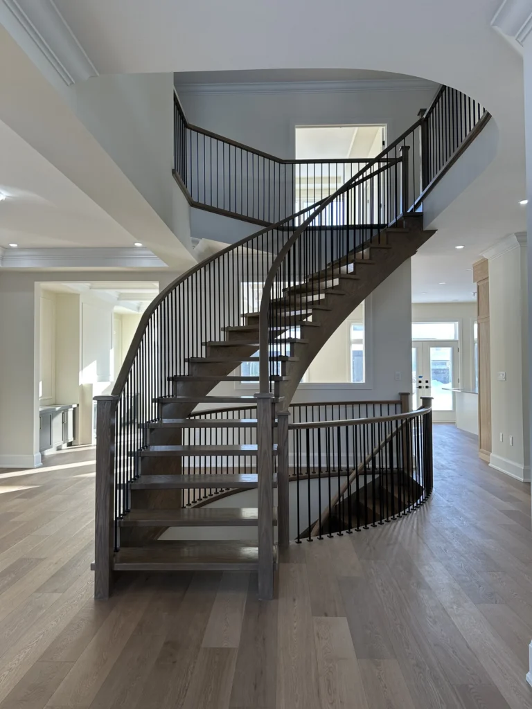 Curved open-riser staircase with iron railing