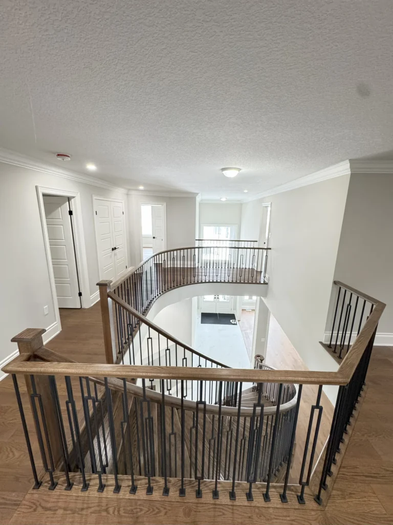 Upstairs landing with oak railing and iron spindles overlooking the foyer