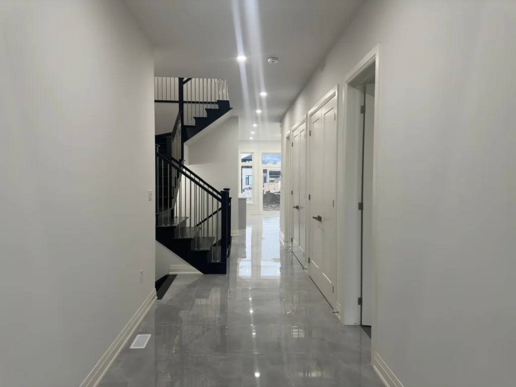 Front hallway with polished porcelain tile and a black staircase