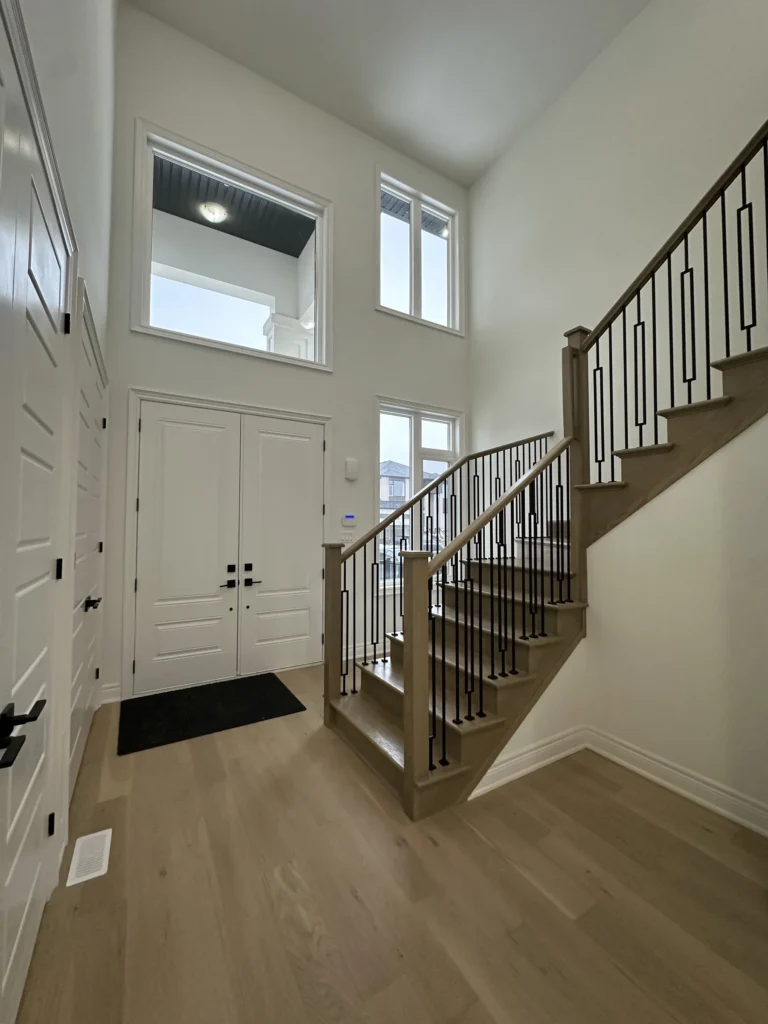 Foyer with double front doors and an oak staircase with iron spindles